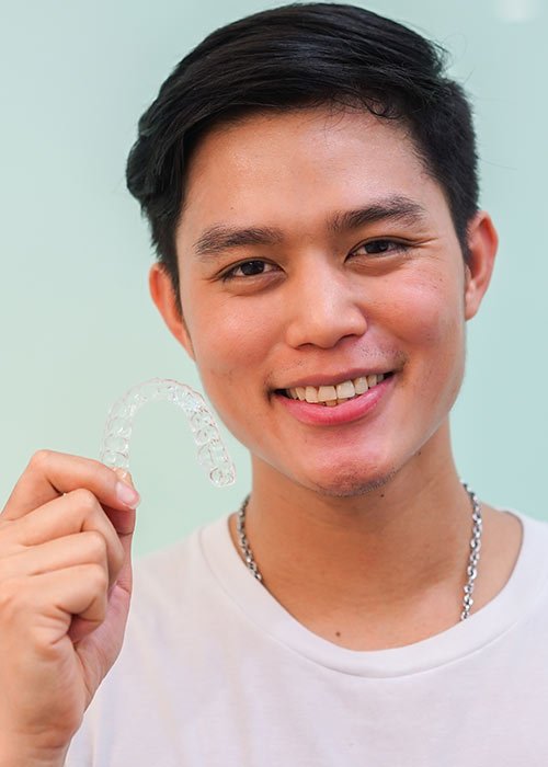boy holding Invisalign in his hand